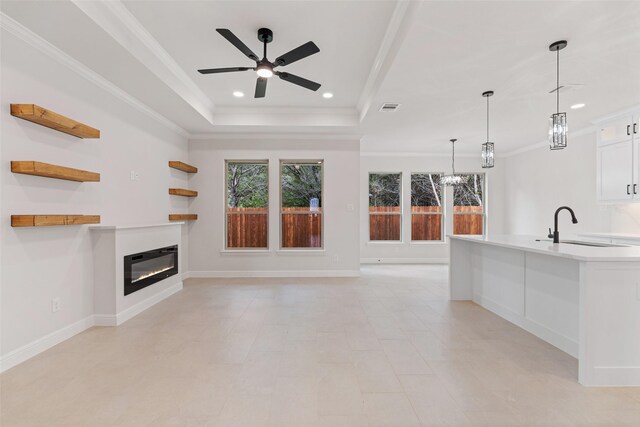 5627 Barkridge Dr, Granbury, TX 76048 - unfurnished living room featuring a raised ceiling, a ceiling fan, a glass covered fireplace, recessed lighting, and a sink