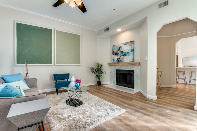 4040 Avondale Ave Unit 201, Dallas, TX 75219 - living area with ornamental molding, wood finished floors, a ceiling fan, a high end fireplace, and baseboards