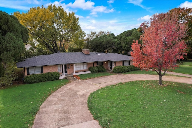 6106 Linden Ln, Dallas, TX 75230 - ranch-style house with curved driveway, a front yard, a chimney, and brick siding