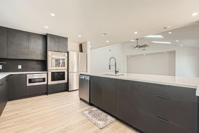 16212 Spring Creek Rd, Dallas, TX 75248 - kitchen featuring a sink, stainless steel appliances, modern cabinets, light wood-style floors, and a ceiling fan