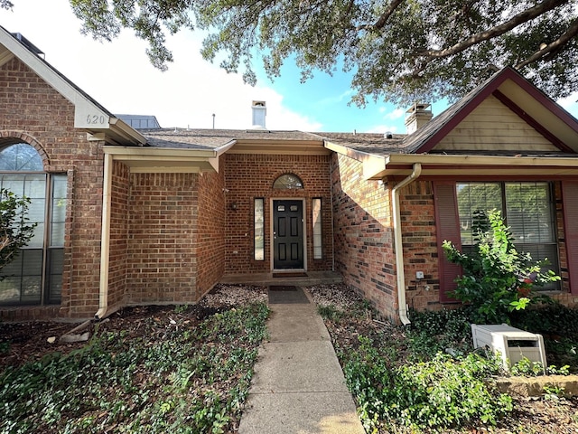 3620 Hilltop Ln, Plano, TX 75023 - property entrance with brick siding, a chimney, and roof with shingles