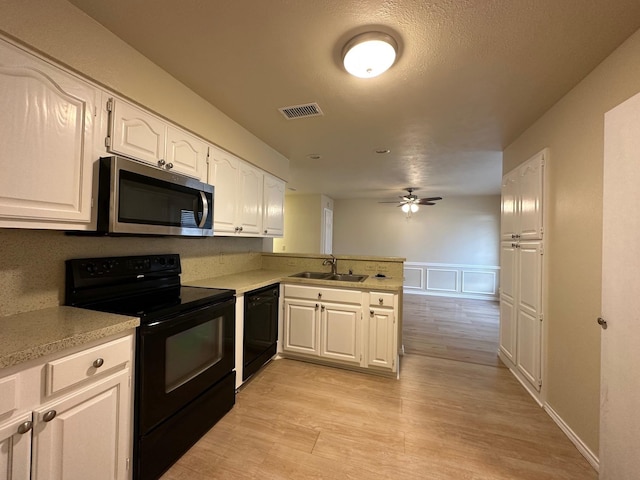 3620 Hilltop Ln, Plano, TX 75023 - kitchen with black appliances, a sink, a peninsula, light countertops, and white cabinets