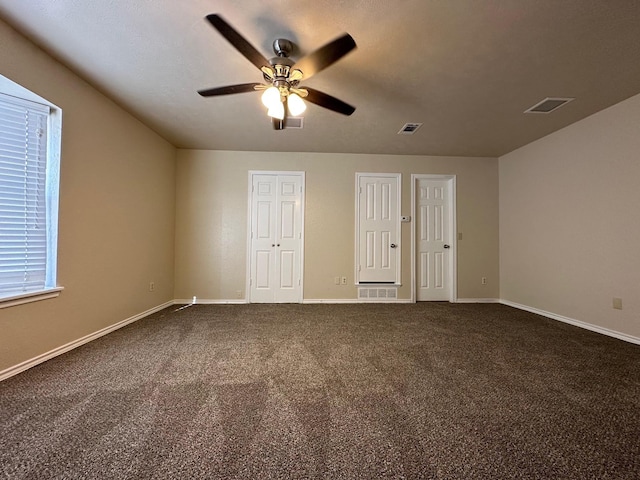 3620 Hilltop Ln, Plano, TX 75023 - unfurnished bedroom with two closets, dark colored carpet, baseboards, and ceiling fan