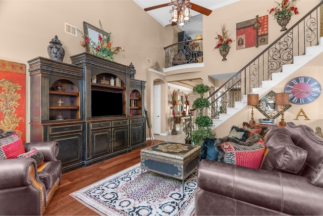 7904 Linksview Dr, Mckinney, TX 75072 - living room featuring stairs, wood finished floors, ceiling fan, a towering ceiling, and crown molding