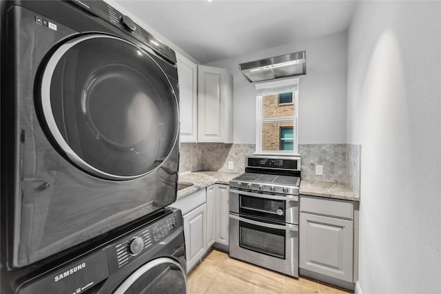 1030 Speargrass Ln, Prosper, TX 75078 - kitchen featuring double oven range, stacked washer and clothes dryer, light stone counters, and tasteful backsplash