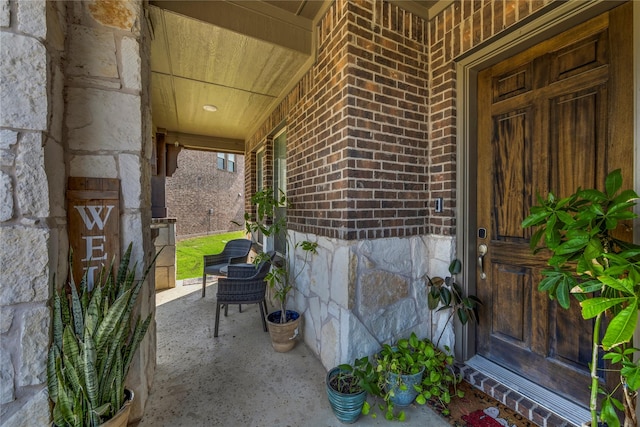 1030 Speargrass Ln, Prosper, TX 75078 - view of exterior entry with brick siding, covered porch, and stone siding