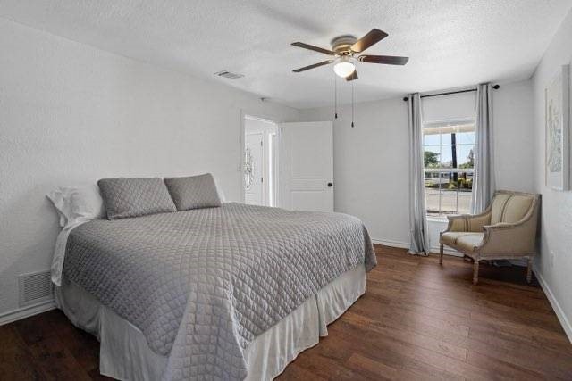 4504 Hodgkins Rd, Lake Worth, TX 76135 - bedroom featuring wood finished floors, baseboards, a textured ceiling, and a ceiling fan