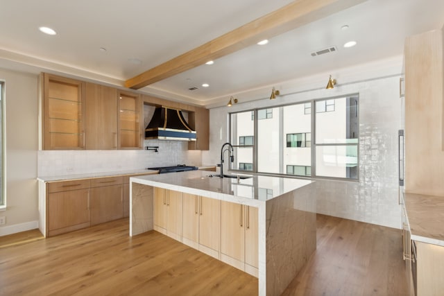 4929 Blaynes Vw, The Colony, TX 75056 - kitchen featuring wall chimney exhaust hood, a sink, light wood-type flooring, backsplash, and a large island