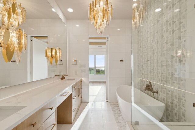 4929 Blaynes Vw, The Colony, TX 75056 - bathroom with tile walls, double vanity, a soaking tub, and tile patterned flooring