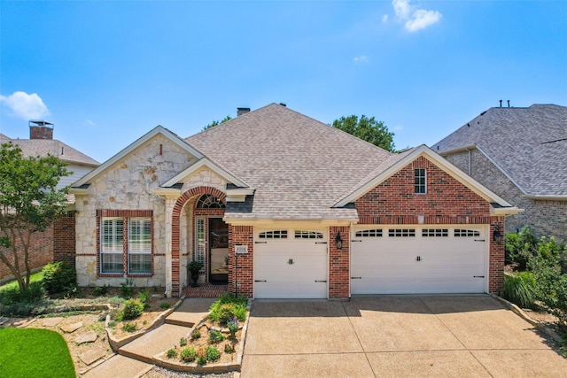 8304 Old Hickory Ln, Mckinney, TX 75072 - view of front facade with an attached garage, concrete driveway, stone siding, and brick siding