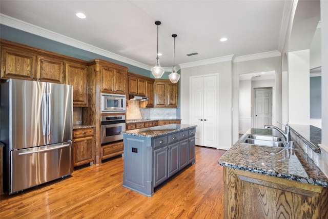 8304 Old Hickory Ln, Mckinney, TX 75072 - kitchen featuring stainless steel appliances, a sink, a center island, light wood-style floors, and dark stone countertops