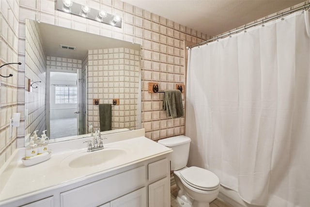8304 Old Hickory Ln, Mckinney, TX 75072 - bathroom with toilet, vanity, curtained shower, and tile walls