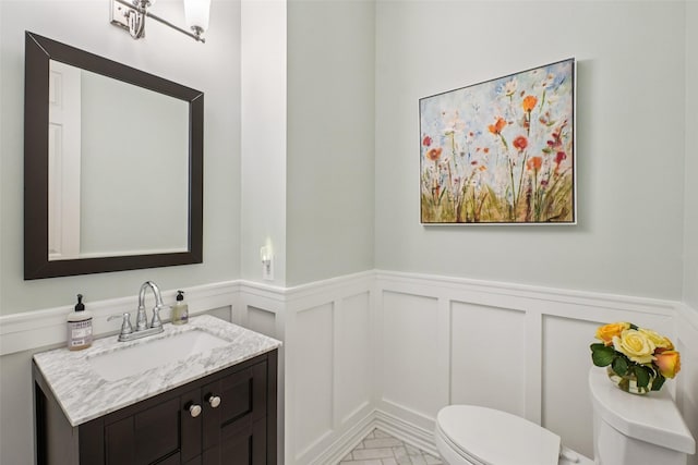8304 Old Hickory Ln, Mckinney, TX 75072 - half bath with toilet, a wainscoted wall, vanity, marble finish floors, and a decorative wall