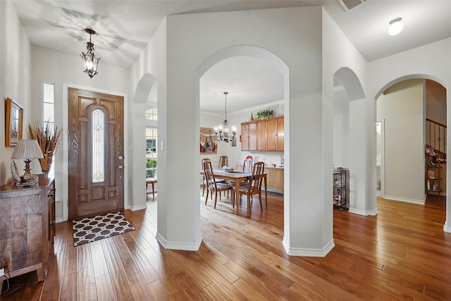 14708 Myrtle Beach Ln, Frisco, TX 75035 - entryway with a chandelier, light wood-style flooring, baseboards, and arched walkways