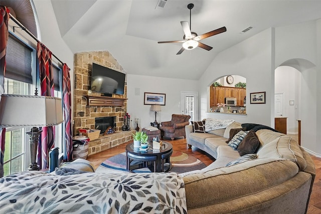 14708 Myrtle Beach Ln, Frisco, TX 75035 - living area with arched walkways, wood finished floors, a ceiling fan, a stone fireplace, and high vaulted ceiling