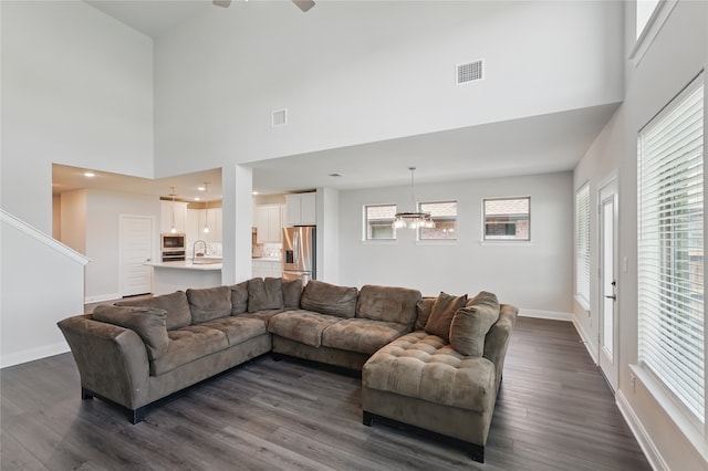 6133 Poolside Way, Royse City, TX 75189 - living room featuring a high ceiling, ceiling fan, baseboards, dark wood-style floors, and a chandelier