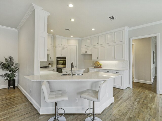 4033 Oakhaven Dr, Plano, TX 75093 - kitchen with a sink, stainless steel double oven, a peninsula, baseboards, and ornamental molding