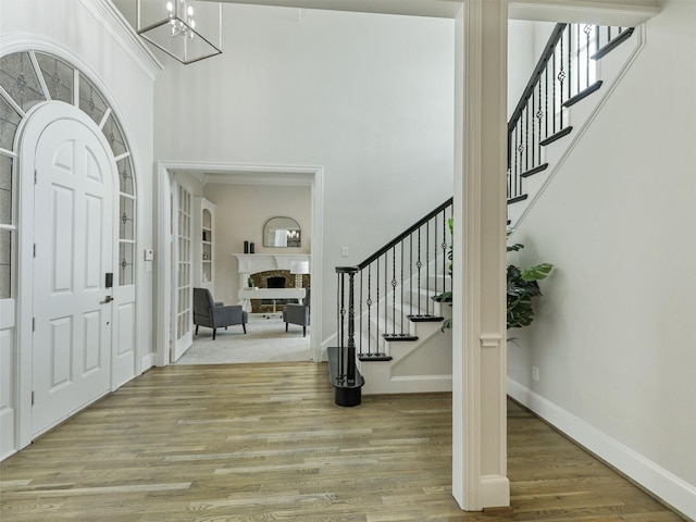 4033 Oakhaven Dr, Plano, TX 75093 - entryway with stairway, light wood-type flooring, a chandelier, a fireplace, and a high ceiling
