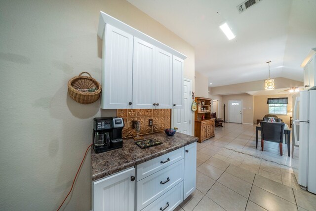 809 W Ball St, Weatherford, TX 76086 - kitchen featuring freestanding refrigerator, backsplash, light tile patterned flooring, white cabinetry, and vaulted ceiling
