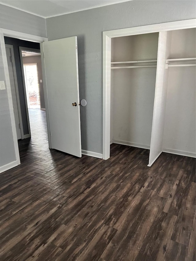 2907 W Collin St, Corsicana, TX 75110 - unfurnished bedroom featuring dark wood-style floors, a closet, and baseboards