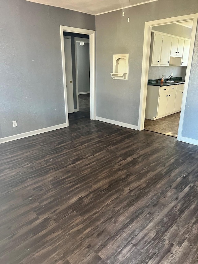 2907 W Collin St, Corsicana, TX 75110 - unfurnished room with dark wood-style flooring, baseboards, and a sink