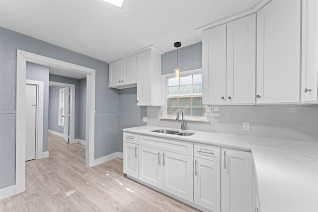 4106 Wheeler St, Fort Worth, TX 76117 - kitchen featuring a sink, white cabinetry, backsplash, baseboards, and light stone counters