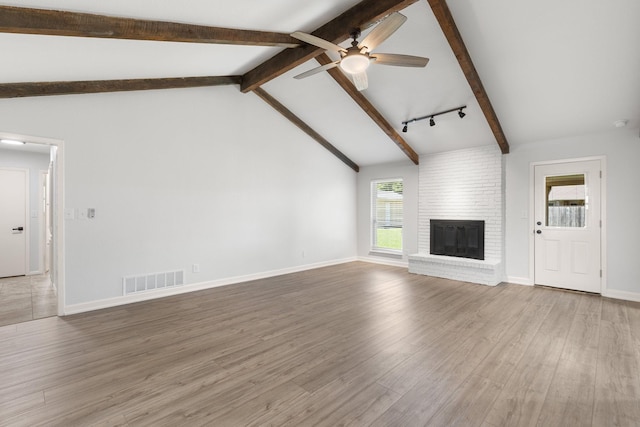 4814 Rhea Rd, Wichita Falls, TX 76308 - unfurnished living room featuring ceiling fan, healthy amount of natural light, a brick fireplace, and wood finished floors