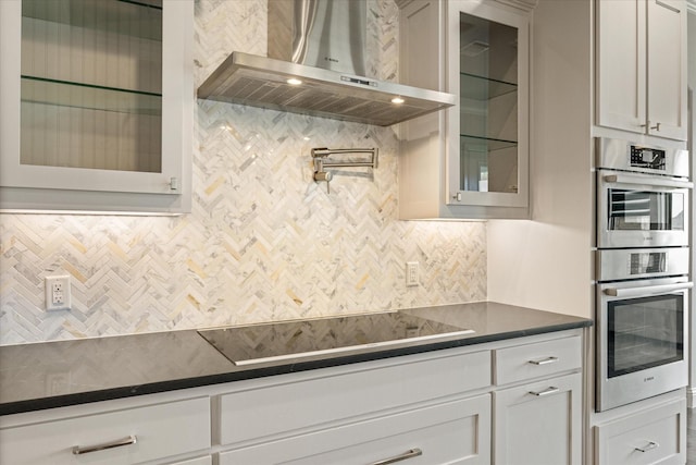 1209 Catalina Bay Blvd, Granbury, TX 76048 - kitchen with exhaust hood, black electric cooktop, dark countertops, double oven, and decorative backsplash