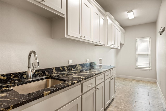 1209 Catalina Bay Blvd, Granbury, TX 76048 - kitchen with a sink, dark stone countertops, white cabinets, and baseboards
