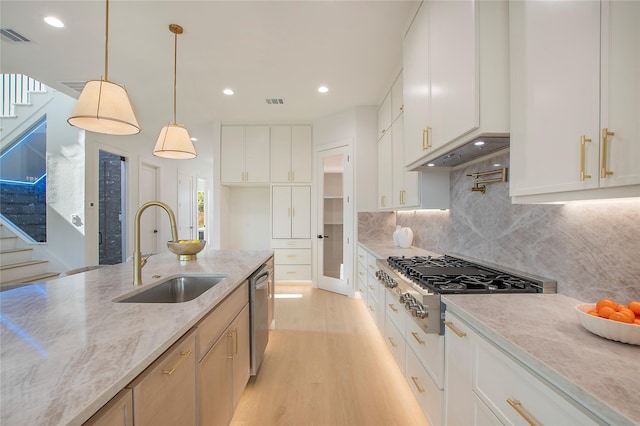 1903 Mcbroom St, Dallas, TX 75212 - kitchen featuring appliances with stainless steel finishes, a sink, light wood-style flooring, custom exhaust hood, and light stone counters