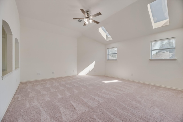 1213 Sonoma Dr, Allen, TX 75013 - empty room featuring a skylight, light colored carpet, lofted ceiling, ceiling fan, and arched walkways