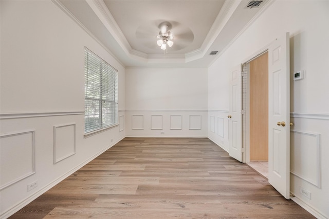 1213 Sonoma Dr, Allen, TX 75013 - spare room featuring a ceiling fan, ornamental molding, a tray ceiling, and light wood-type flooring