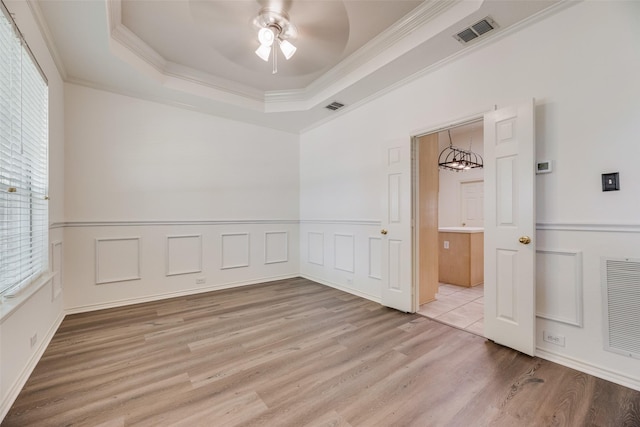 1213 Sonoma Dr, Allen, TX 75013 - spare room with light wood-style flooring, a raised ceiling, a ceiling fan, crown molding, and a wainscoted wall