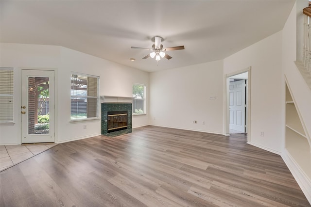 1213 Sonoma Dr, Allen, TX 75013 - unfurnished living room featuring a tiled fireplace, ceiling fan, wood finished floors, and baseboards