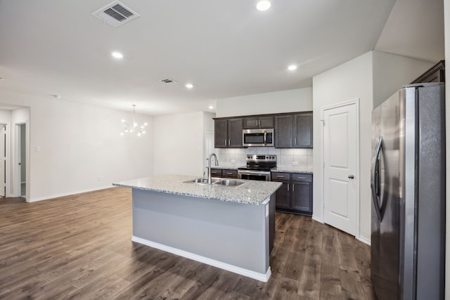 913 Alton Dr, Aubrey, TX 76227 - kitchen with appliances with stainless steel finishes, a chandelier, a kitchen island with sink, dark wood-style flooring, and recessed lighting