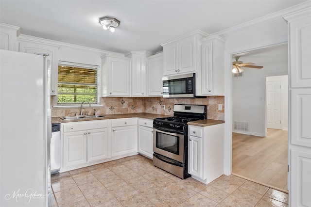 5710 Grover Pl, Shreveport, LA 71105 - kitchen featuring stainless steel appliances, a sink, decorative backsplash, white cabinetry, and ceiling fan