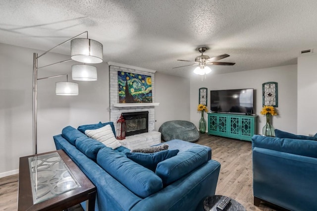 238 Browning Ln, Grand Prairie, TX 75052 - living area with wood finished floors, a ceiling fan, a textured ceiling, and a fireplace