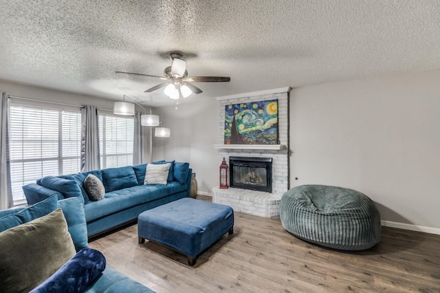 238 Browning Ln, Grand Prairie, TX 75052 - living area with baseboards, wood finished floors, ceiling fan, a fireplace, and a textured ceiling