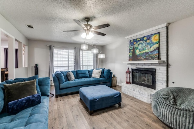 238 Browning Ln, Grand Prairie, TX 75052 - living area featuring a ceiling fan, wood finished floors, a textured ceiling, and a fireplace