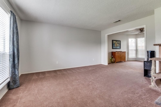 238 Browning Ln, Grand Prairie, TX 75052 - unfurnished living room featuring carpet floors, a wood stove, a textured ceiling, a ceiling fan, and baseboards