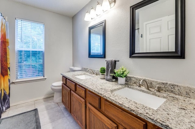 238 Browning Ln, Grand Prairie, TX 75052 - bathroom featuring toilet, double vanity, tile patterned floors, and baseboards