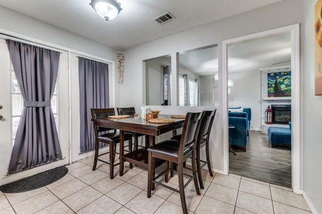 238 Browning Ln, Grand Prairie, TX 75052 - dining area with light tile patterned floors, a textured ceiling, and baseboards