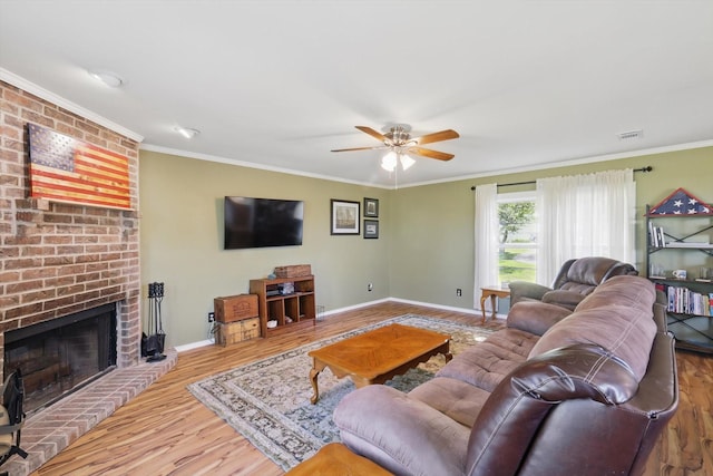 177 Graben Ln, Rhome, TX 76078 - living room featuring wood finished floors, ceiling fan, crown molding, baseboards, and a brick fireplace
