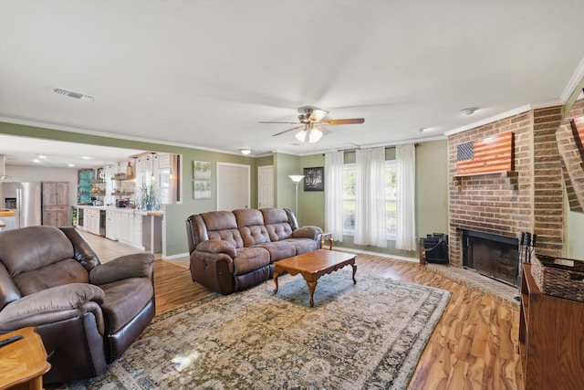 177 Graben Ln, Rhome, TX 76078 - living area with ceiling fan, light wood finished floors, a brick fireplace, ornamental molding, and baseboards