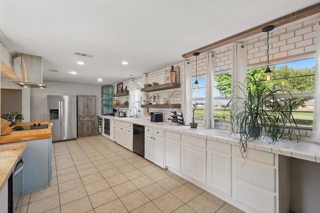 177 Graben Ln, Rhome, TX 76078 - kitchen with black appliances, light tile patterned flooring, white cabinets, wooden counters, and a sink