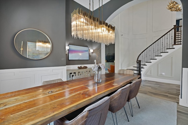 4350 Bristleleaf Ln, Prosper, TX 75078 - dining room with a decorative wall, stairway, wood finished floors, a chandelier, and a high ceiling