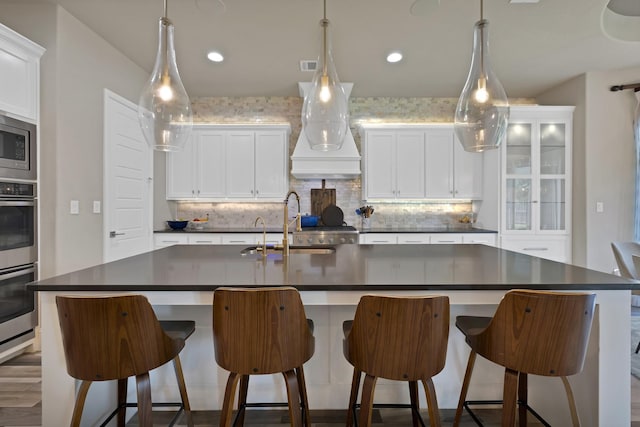 4350 Bristleleaf Ln, Prosper, TX 75078 - kitchen with dark countertops, a sink, an island with sink, backsplash, and recessed lighting