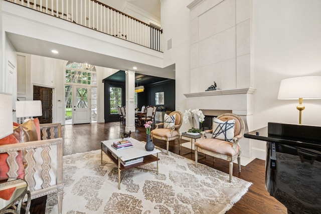 1260 Stanhope Ct, Southlake, TX 76092 - living room featuring wood finished floors, decorative columns, a chandelier, a fireplace, and a towering ceiling