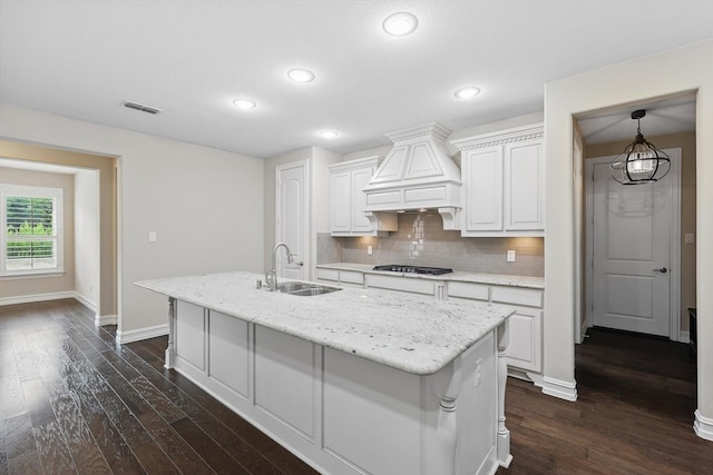 2866 Milsons Point Dr, Trophy Club, TX 76262 - kitchen with custom exhaust hood, dark wood-type flooring, tasteful backsplash, white cabinetry, and an island with sink