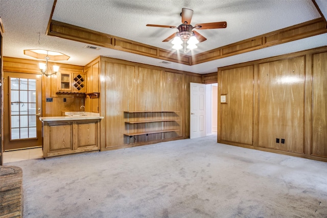 4465 Northern Dancer Dr, Burleson, TX 76028 - unfurnished living room with a textured ceiling, wooden walls, light carpet, ceiling fan, and bar area